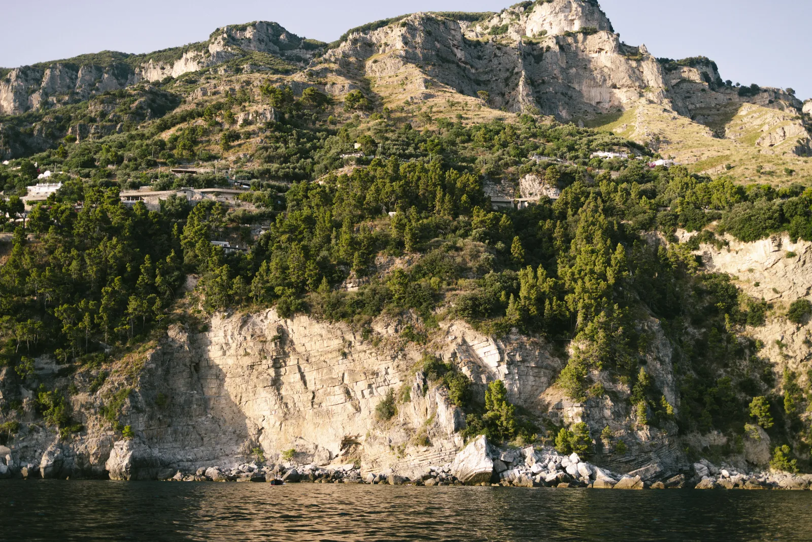Pastel houses cascading down the cliffs above a blue bay in Positano on the Amalfi Coast, Italy