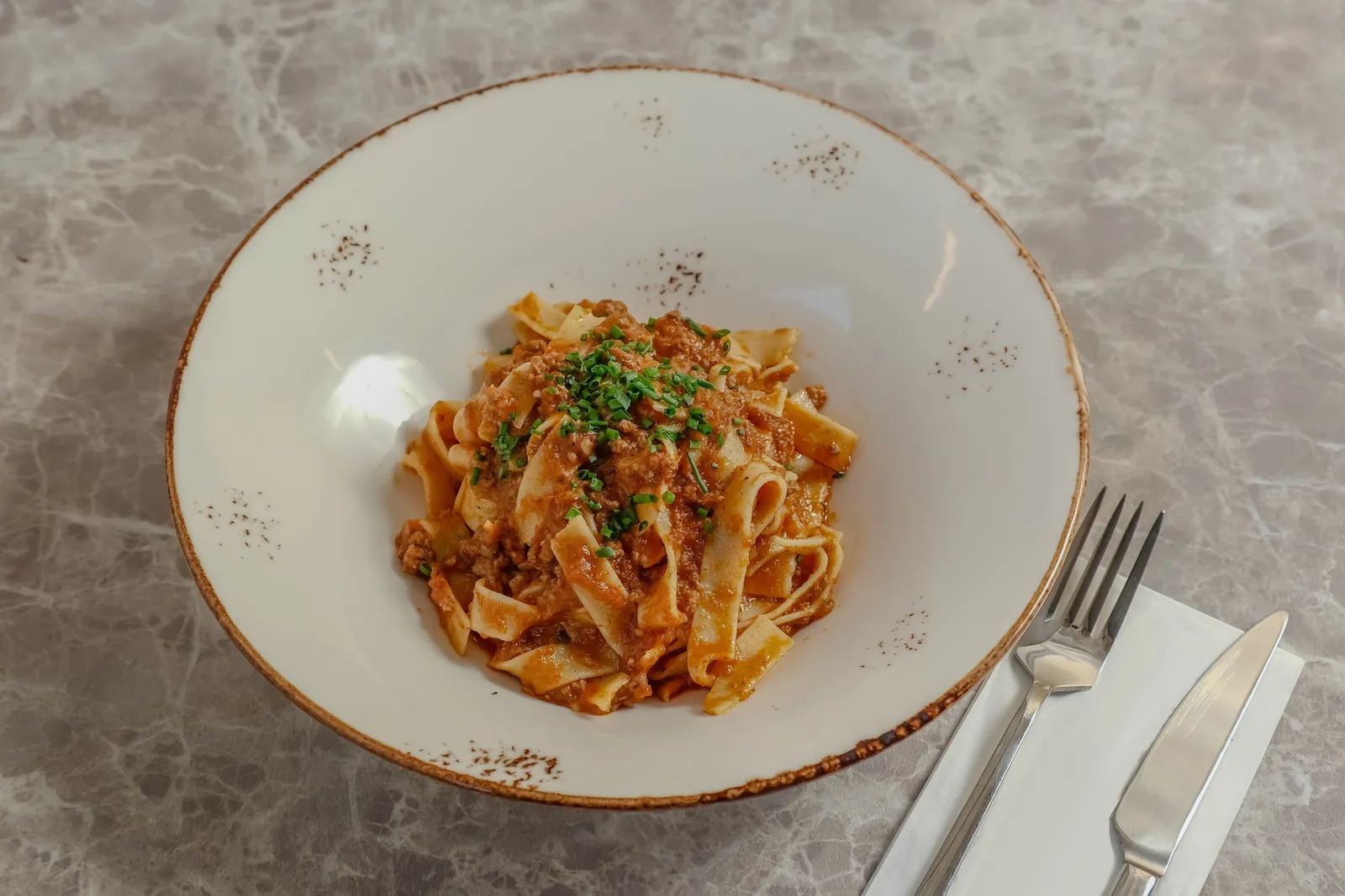 A plate of fresh tagliatelle pasta with ragu sauce in a trattoria in Bologna, Italy
