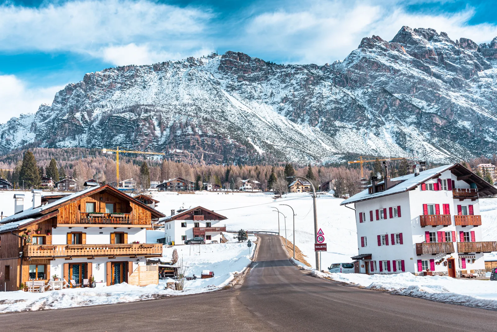 A snow covered village street beneath the peaks of the Dolomites, Italy