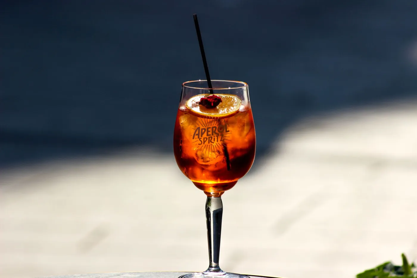 An Aperol spritz with an orange slice on a table at aperitivo hour