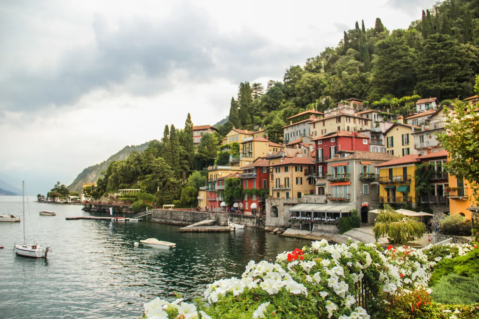 A village of coloured houses on the shore of Lake Como with mountains behind, Italy