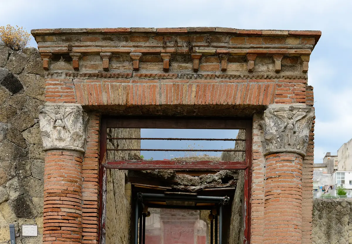 Ancient Roman brick gateway with a stone cornice and restored columns