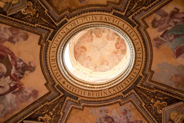 A frescoed dome ringed with a gilded inscription above the nave
