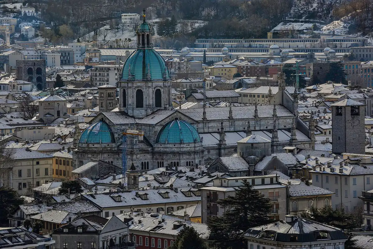 Green copper domes of a Gothic cathedral among snow dusted town rooftops