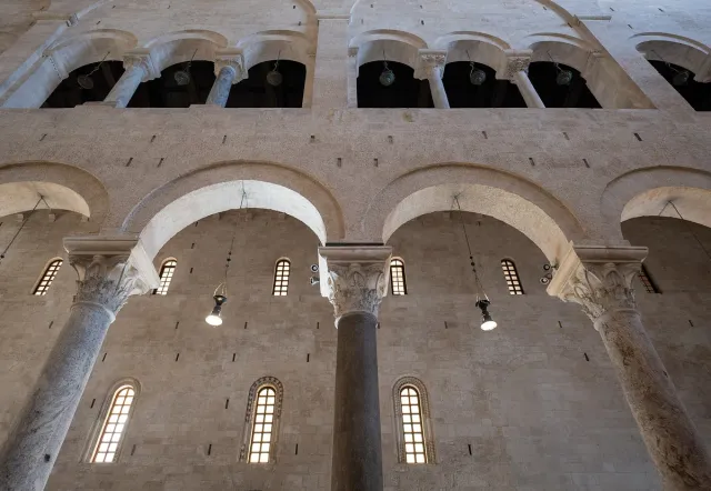 Pale stone arches and columns in a Romanesque church interior