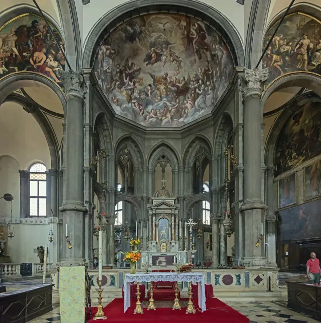 A Gothic church interior with painted vaults and a gilded marble altar