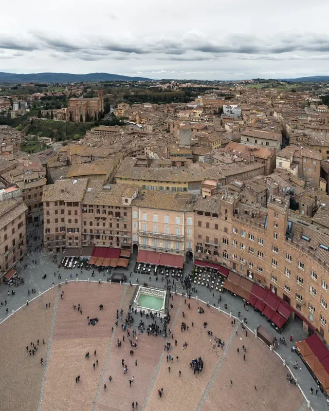 A view from above onto a fan shaped paved square ringed by palaces
