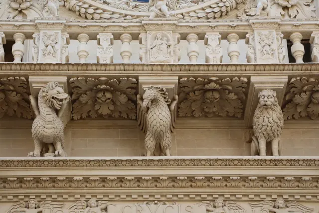 A stone balcony carried on richly carved baroque figures and beasts
