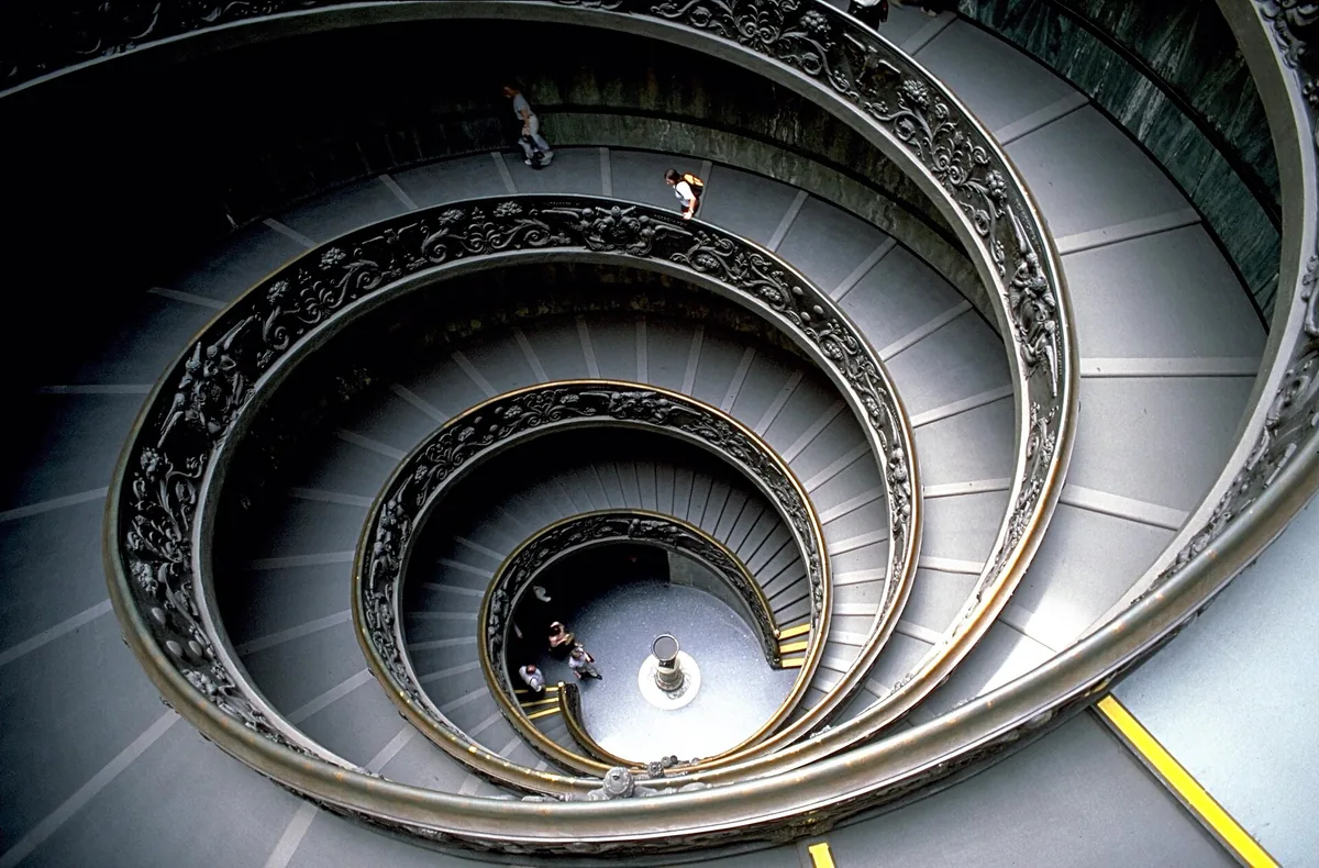 Overhead view of a double spiral staircase with an ornate bronze balustrade