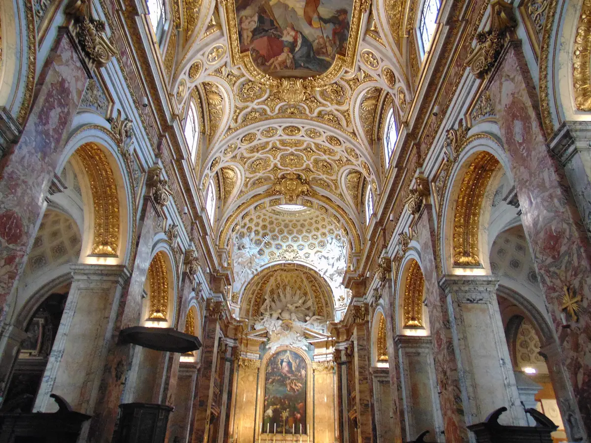 A gilded vaulted ceiling above a row of marble columns in a church nave