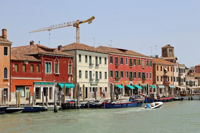 Colourful houses along a canal with moored boats and a quay