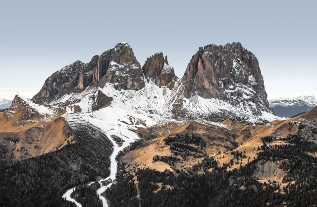 Jagged rock peaks streaked with snow above bare slopes