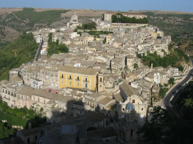 A dense stone town on a hillside with domes and tiled roofs