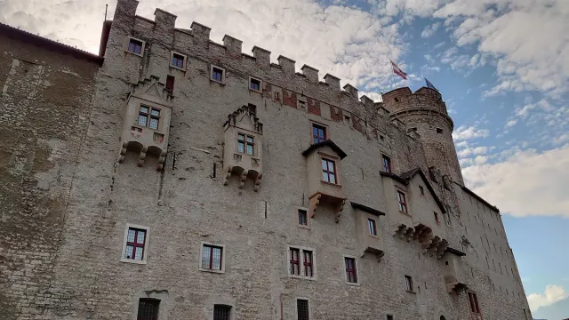 A stone castle wall with painted decoration and arched windows