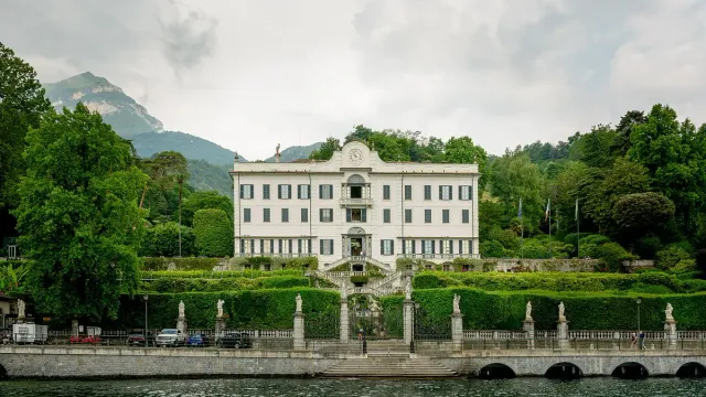 A white villa above a terraced garden running down to a lake shore