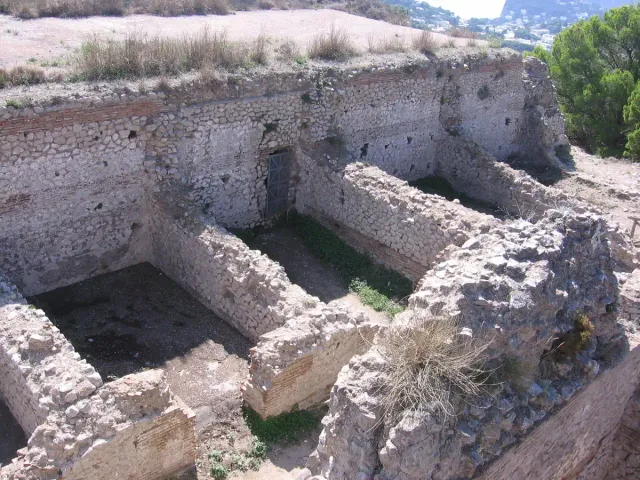 White stone rooms and cisterns of an ancient ruin site in daylight
