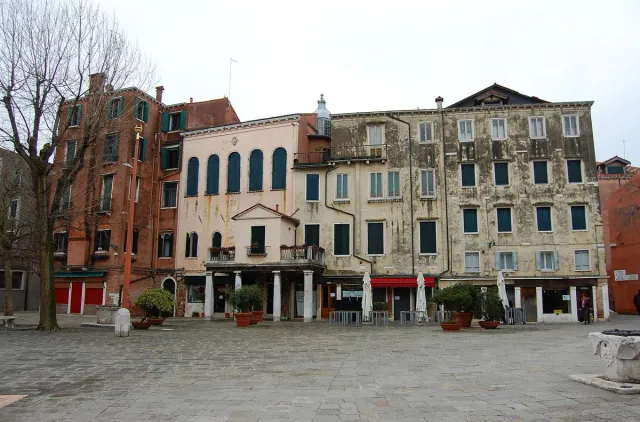 A wide quiet square enclosed by tall shuttered houses