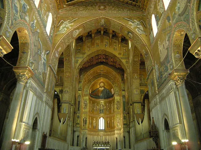 A church interior sheathed in gold mosaic with a giant figure in the vault