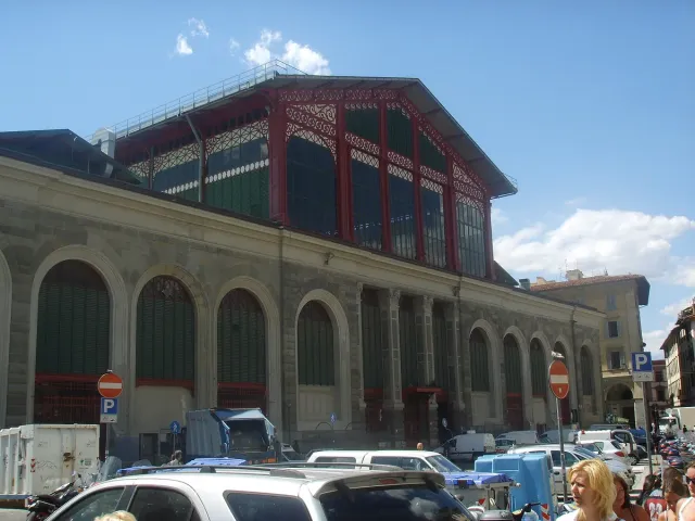 An iron and glass market hall with arched windows on a city street