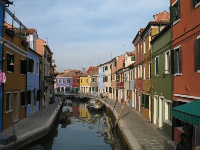 A narrow canal between brightly painted houses with moored boats