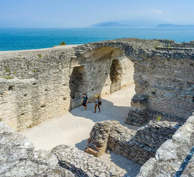 Roman stone vaults and ruins above the sea with visitors