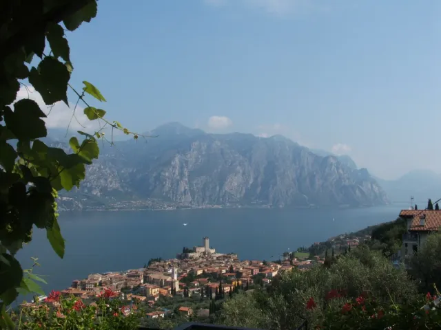 A town with a castle on a headland above a wide lake and mountains