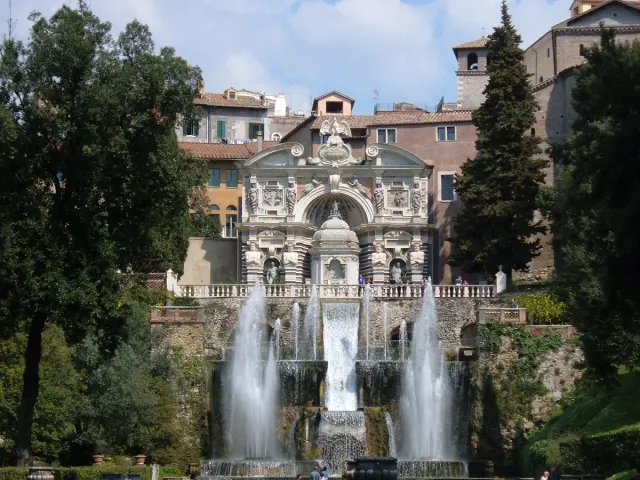 A row of water jets on garden terraces with statues and greenery