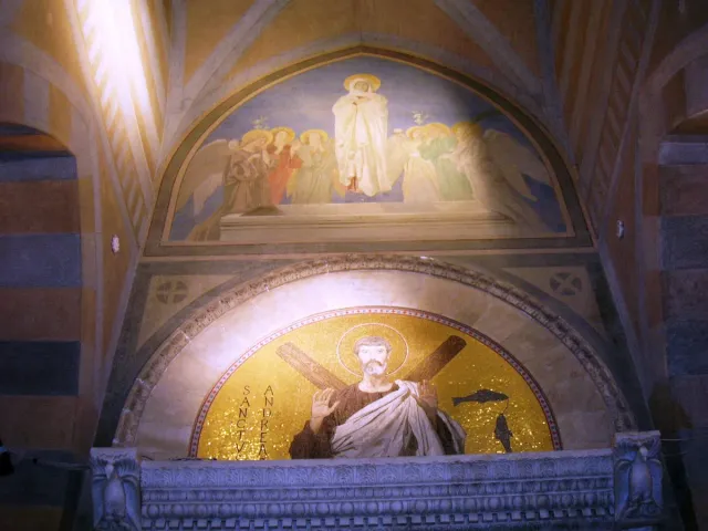 A gilded niche with a marble statue in an ornate church interior