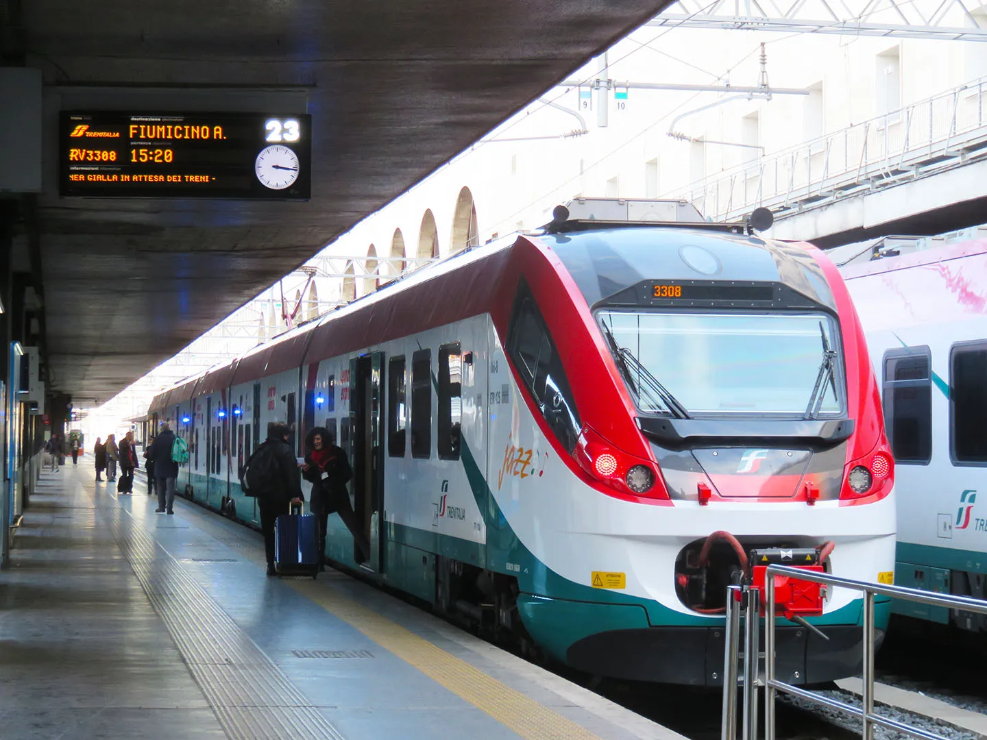 The red and white Leonardo Express airport train waiting at a platform in Roma Termini station