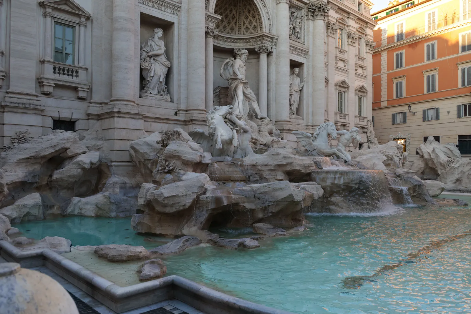 A grand baroque fountain and elegant piazza busy with visitors in central Rome
