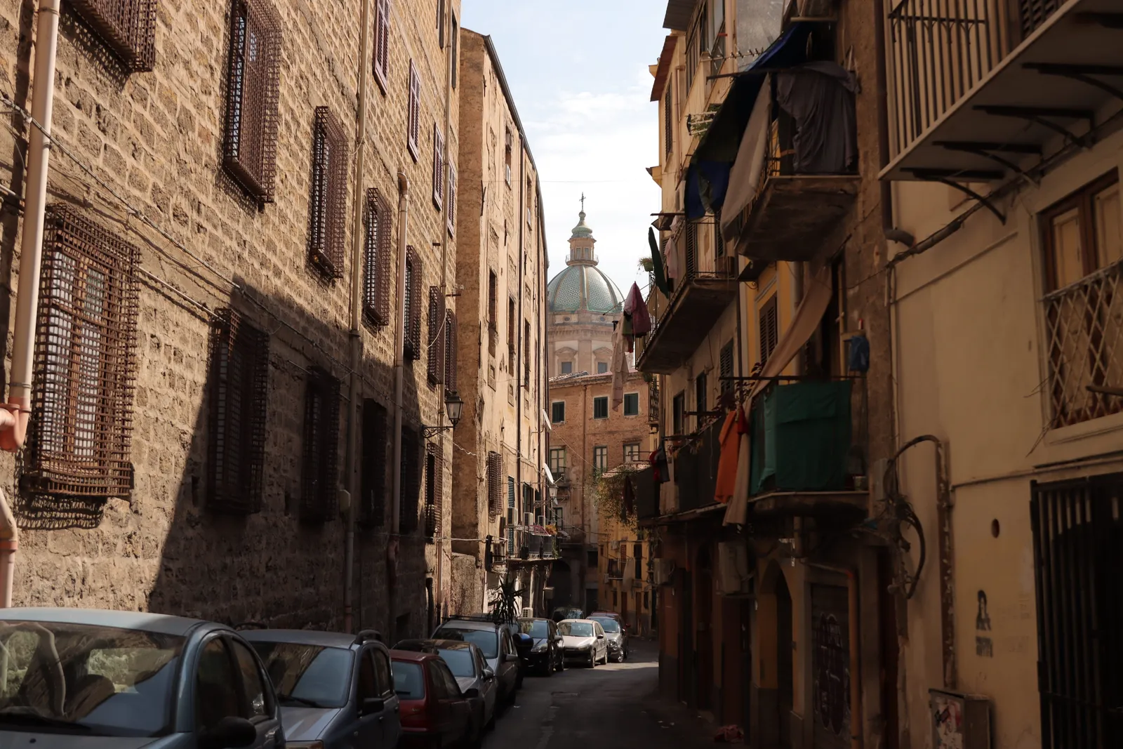 A street in the old centre of Palermo with a church dome behind, Sicily, Italy