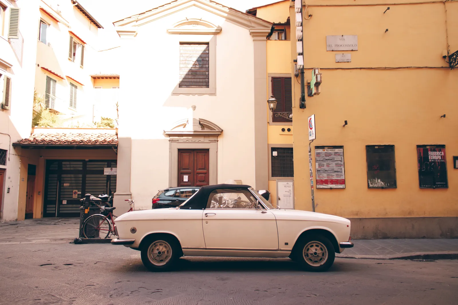 A car on a narrow street in the historic centre of an Italian city