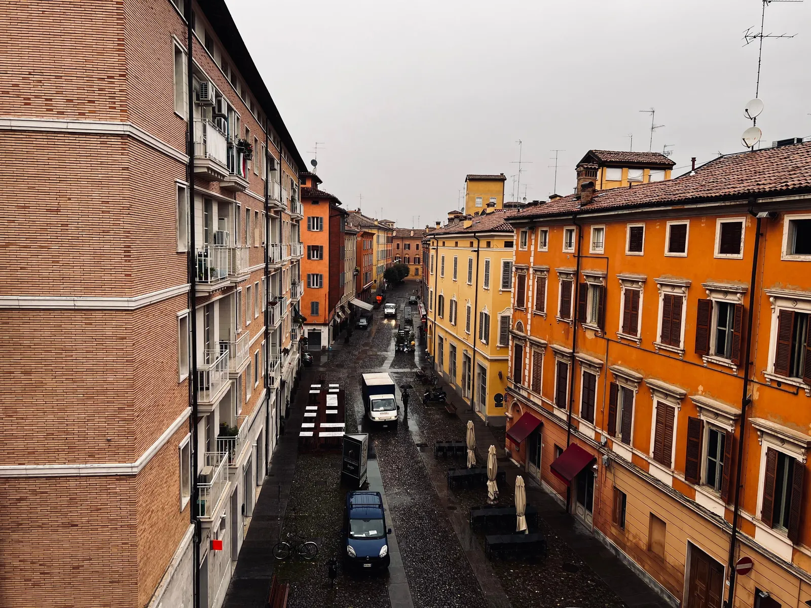A narrow stone street barely wide enough for a car in an Italian town